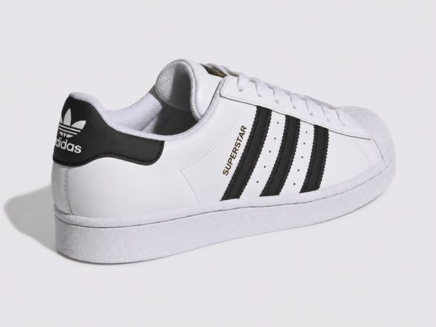 Side-view packshot of a white leather trainer with black stripes on a light grey background