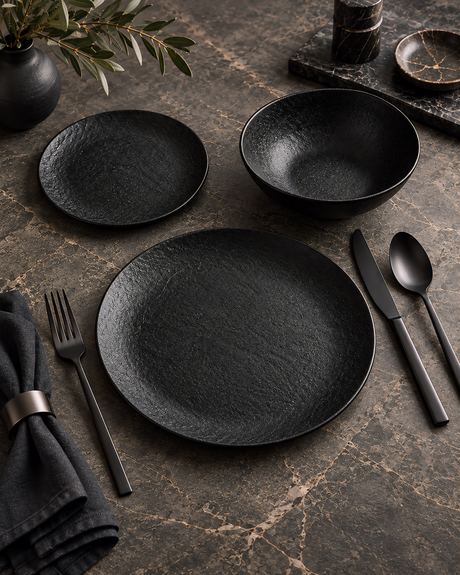 Product photo of a matte black tableware place setting on a dark marble surface