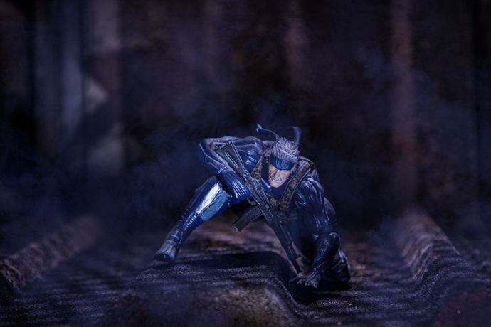 Character photo of an armoured, masked figure crouching in blue shadow