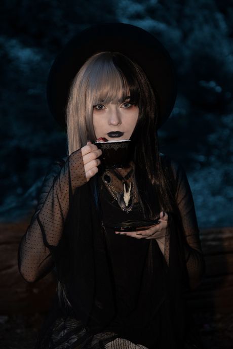 Character portrait in black lace with dark lipstick in low light