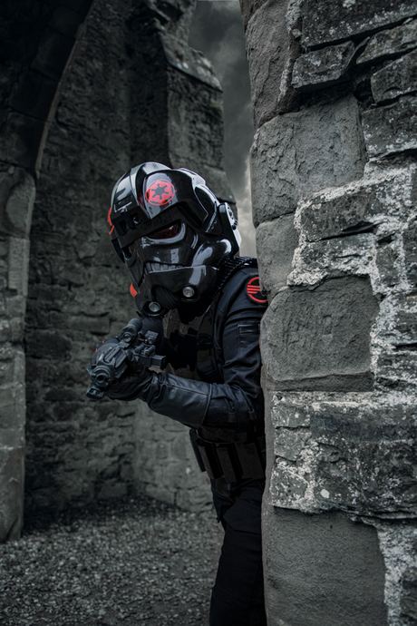 Character photo of a masked figure in black armour in a stone ruin