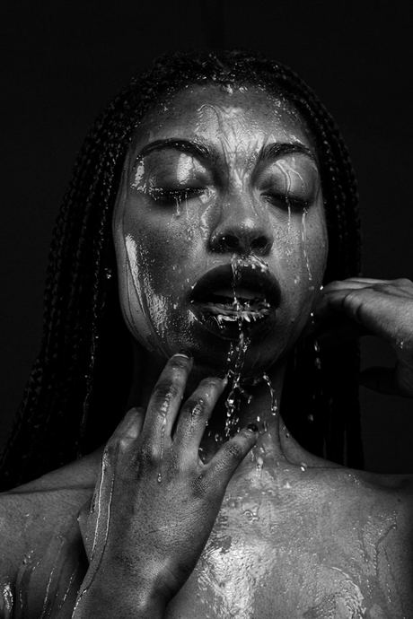 Black and white portrait with water running over the face, eyes closed