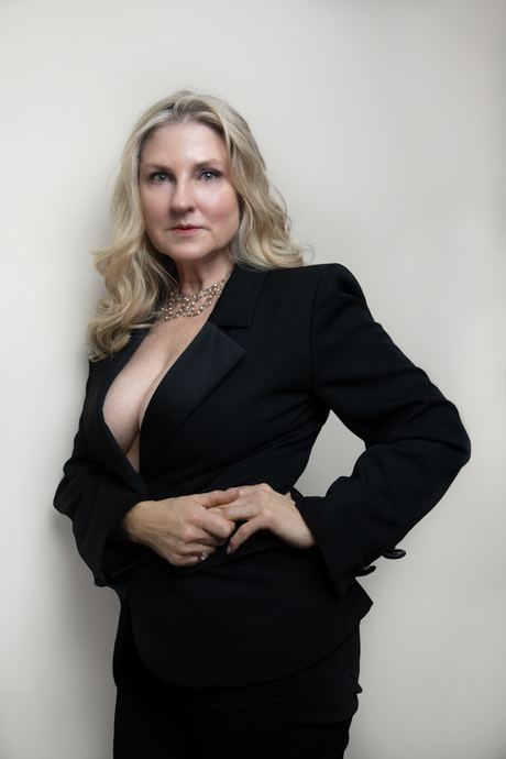Professional portrait of a woman with blonde hair in a black blazer